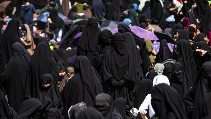 Women stand at the Kurdish-run al-Hol camp, which holds relatives of suspected Islamic State (IS) group fighters in the northeastern Hasakeh governorate, on April 18, 2025.