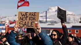 A protester holds a sign reading 'We are not for sale' in front of the US consulate during a demonstration in Nuuk, Greenland, on March 15, 2025.