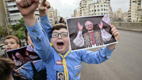 Imam Al-Mahdi scouts hold portraits of Pope Leo XIV as they wait for his arrival in Beirut's southern suburbs, a packed residential area known as Dahiyeh, which is also a Hezbollah bastion.