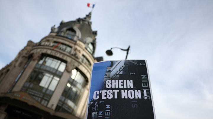 A protester holds up a placard which reads "Shein, no way. Stop fast fashion" during a protest against the online fast-fashion retailer's first Paris store, on November 5, 2025.