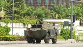 Beninese soldiers take up positions in front of the headquarters of Benin's radio and television station in Cotonou.