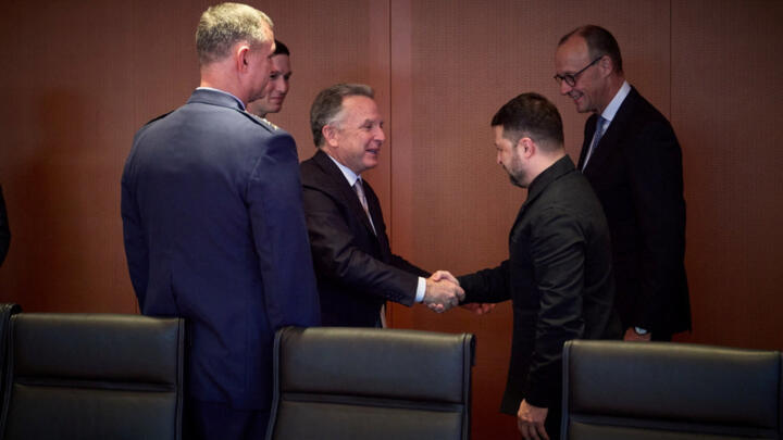 Ukraine's President Volodymyr Zelensky shakes hands with US envoy Steve Witkoff in Berlin on December 14, 2025.