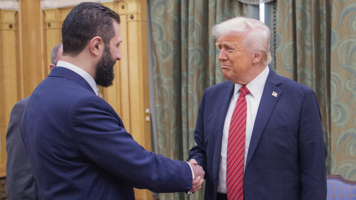 US President Donald Trump (right) shakes hands with Syria's Ahmed al-Sharaa during their first meeting in Riyadh, Saudi Arabia, on May 14, 2025. 