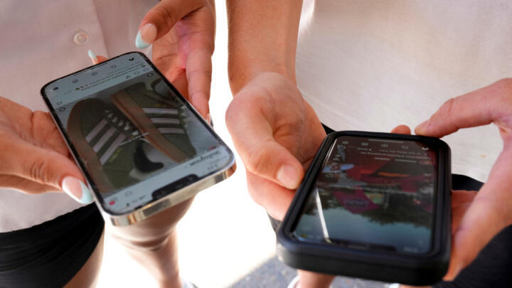 Young people use their phones to view social media in Sydney, Australia.