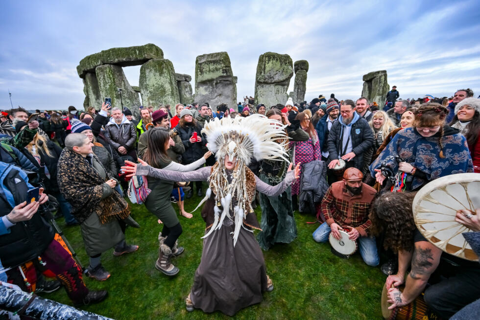Kefan Wang, a shaman from China, and Abbie Coombs from London dance as people celebrate the Winter Solstice sunrise celebrations at Stonehenge, a world-famous prehistoric monument on Salisbury Plain.