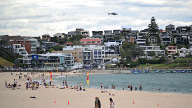 A police helicopter patrols over the Bondi Beach as life gradually returns to normal following seven days of mourning, a week after the Bondi Beach shooting attack, in Sydney on December 22, 2025