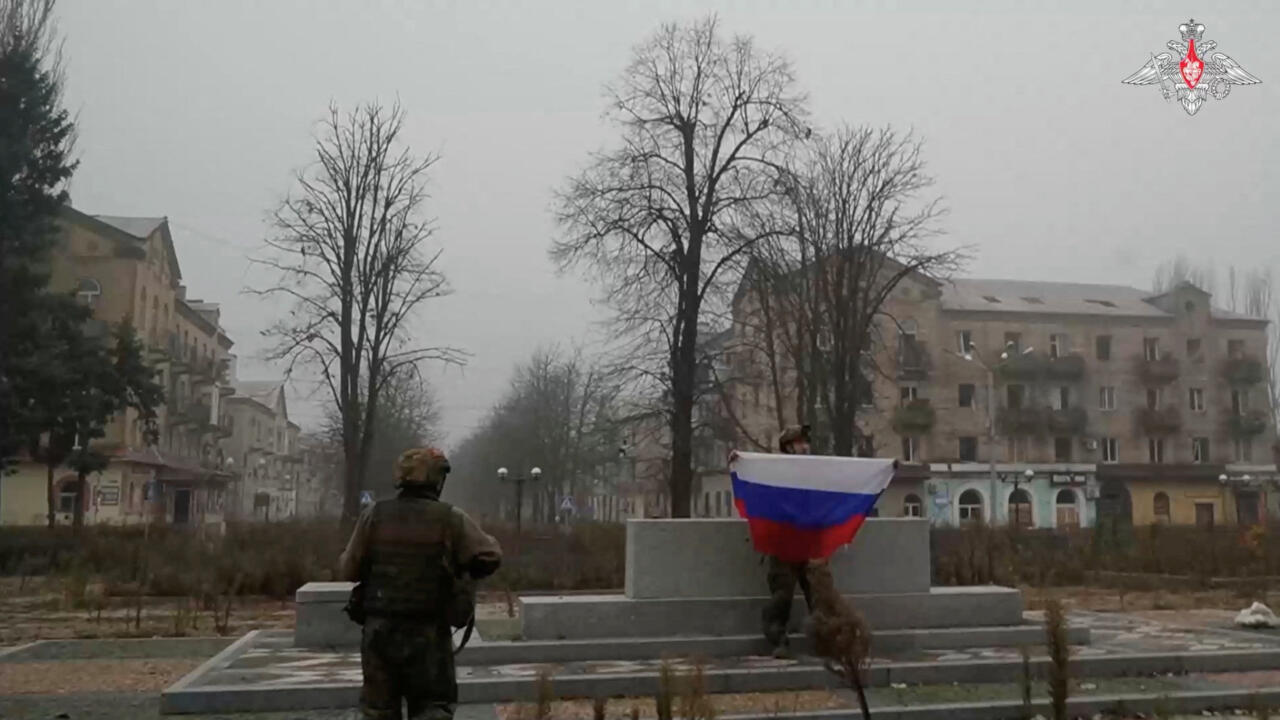 A soldier holds a Russian flag in Pokrovsk, in the Donetsk Region of Ukraine, in this screengrab from video released on December 1, 2025.